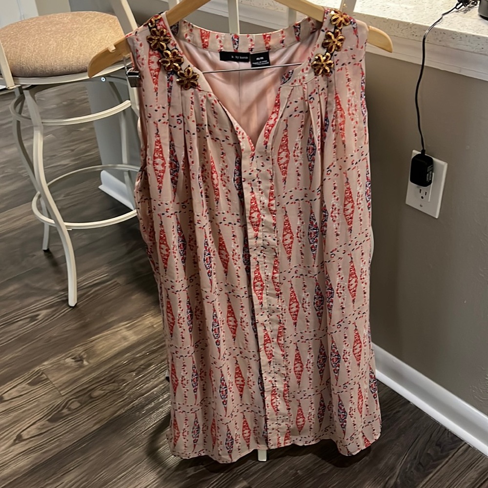 Sleeveless dress with gold flower trim.